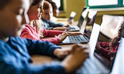 crianças em sala de aula estudando sob orientação de uma educação midiatica